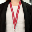 A person in a white top and black blazer wears a red CVMLANR Cerwin-Vega Mobile Lanyard with 