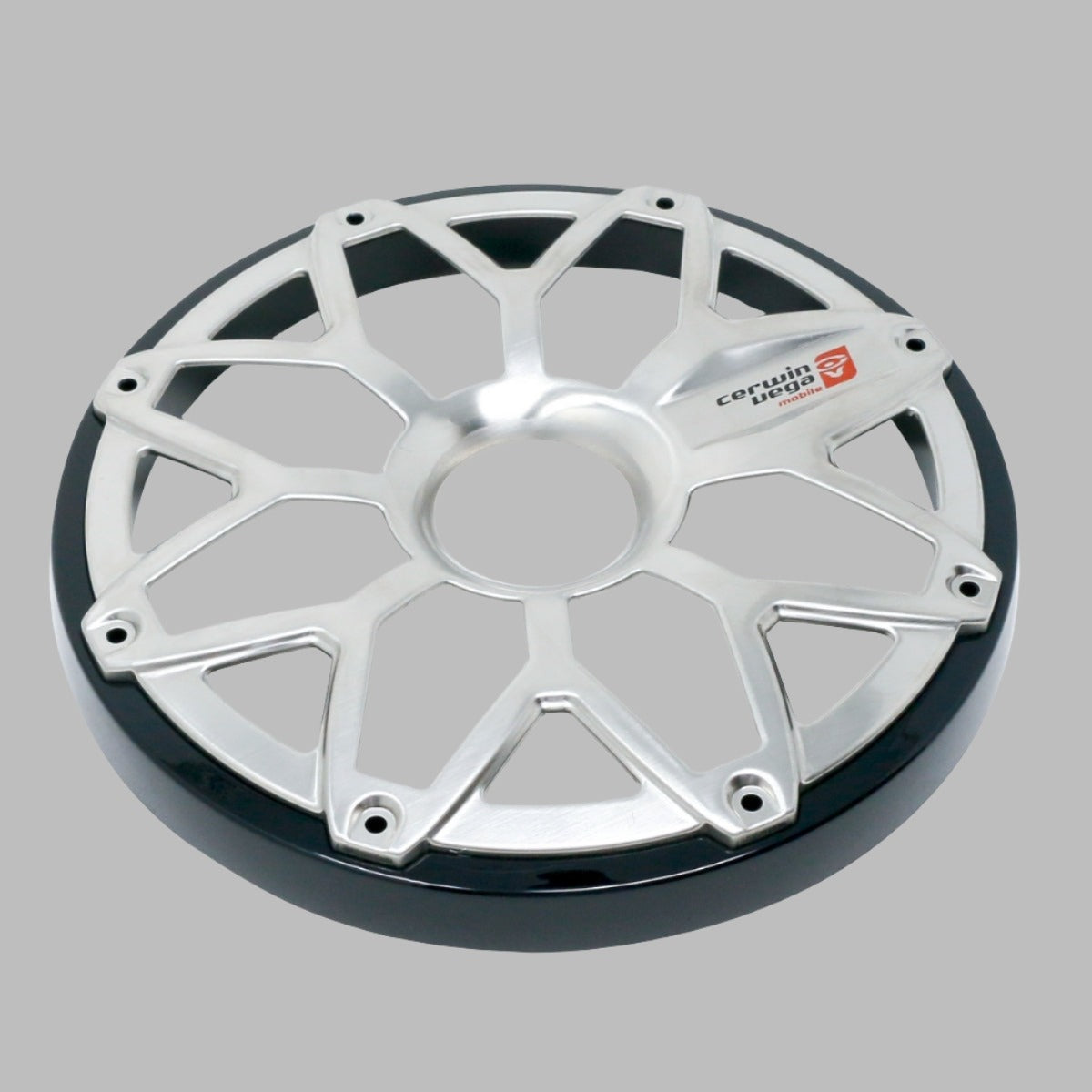 The image shows a silver metallic wheel cover with a design resembling the RPM Stroker 6.5” Flush Mount Speaker Grill. It features spoke-like eight-point extensions forming a star pattern, a shiny black rim edge, and the red and white 